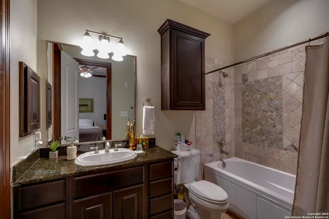 a bathroom with a granite countertop sink toilet and shower