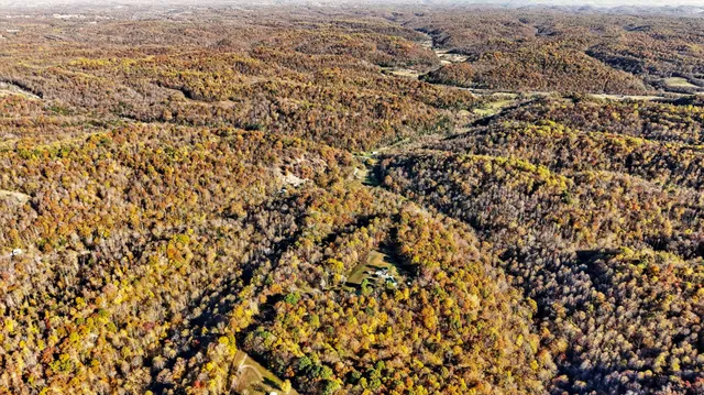 an aerial view of house with yard and mountain view in back