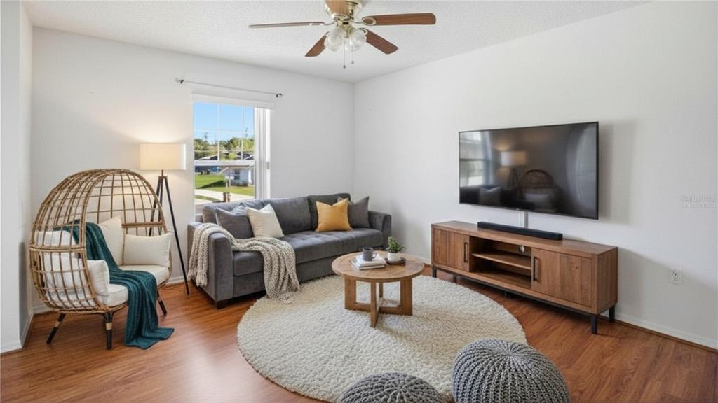 206 Taranto Way Kissimmee, FL 34758 - Photo 20 of 45 a living room with furniture and a flat screen tv