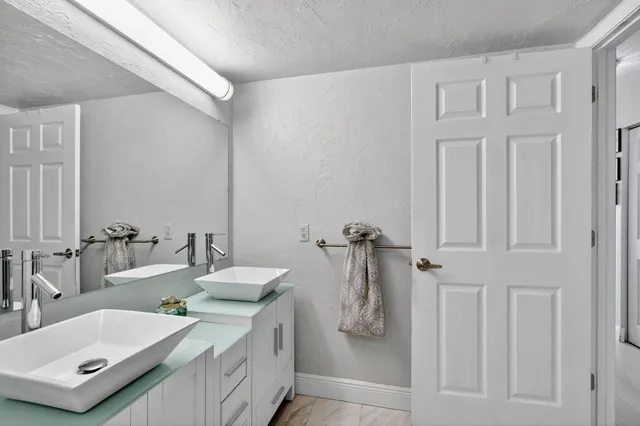 a bathroom with a granite countertop sink and a mirror