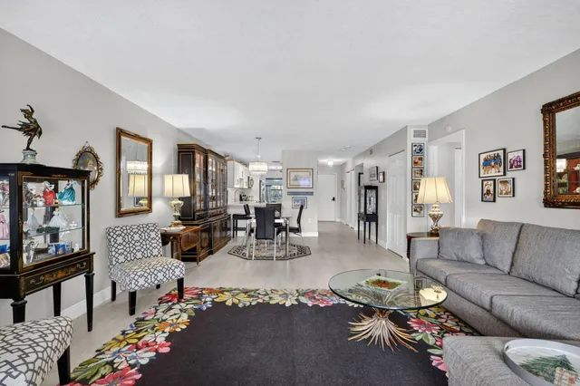 a living room with furniture a flat screen tv and a floor to ceiling window