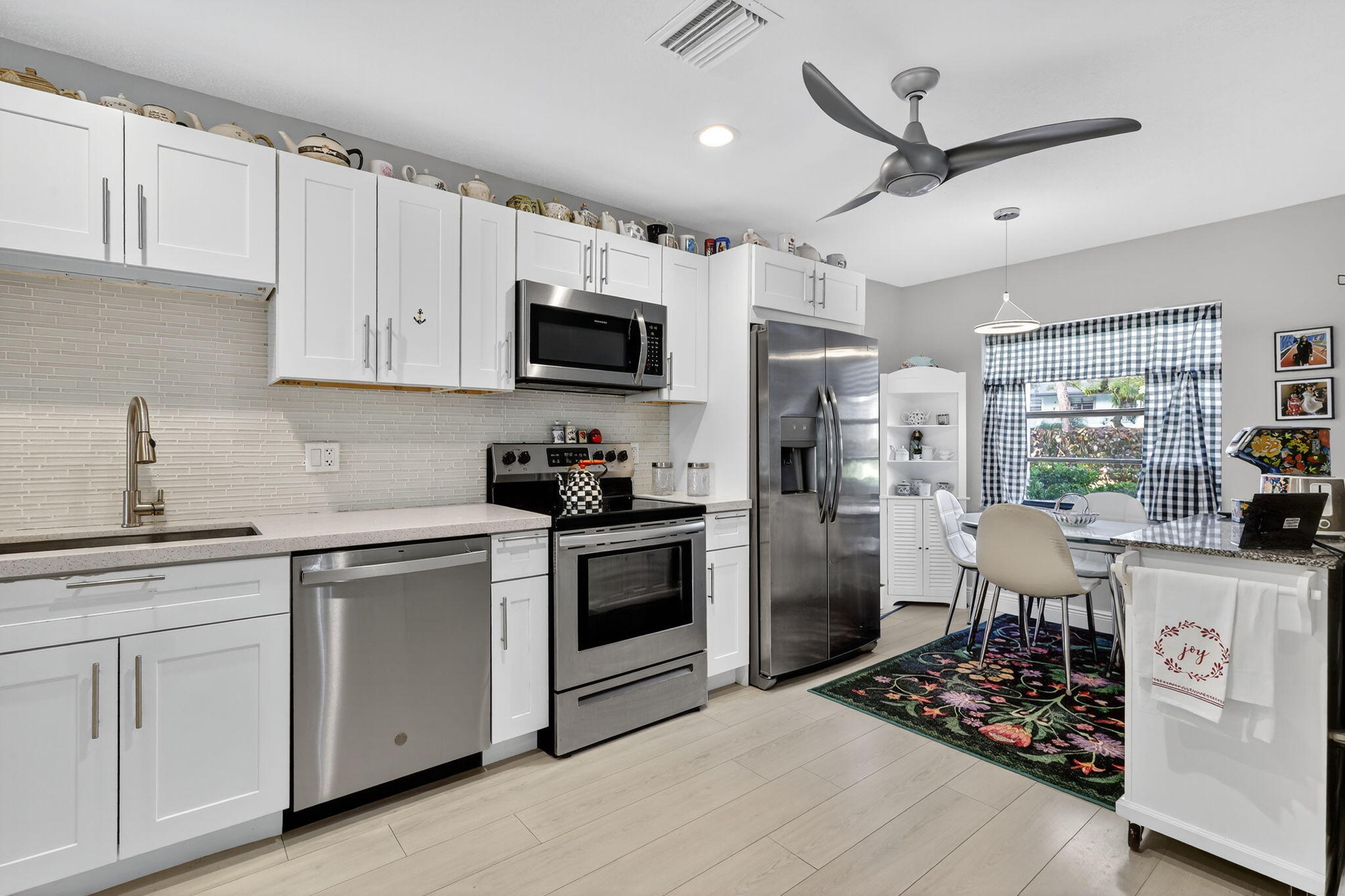 36 Southport Lane, Unit C Boynton Beach, FL 33436 - Photo 4 of 69 a kitchen with stainless steel appliances kitchen island granite countertop a stove sink microwave and refrigerator