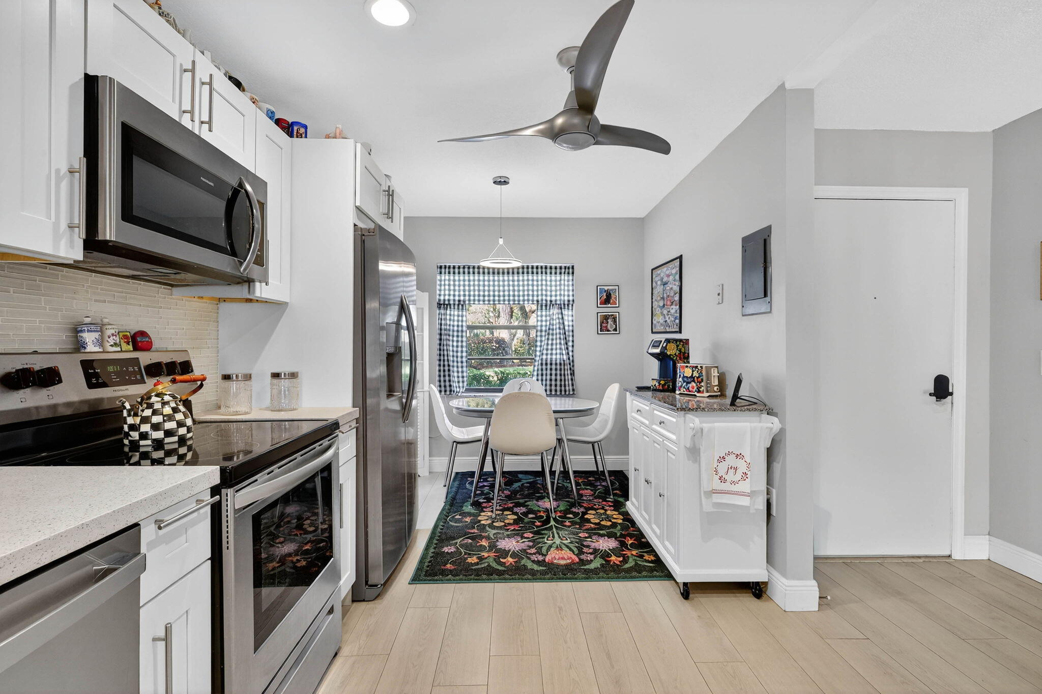 36 Southport Lane, Unit C Boynton Beach, FL 33436 - Photo 5 of 69 a kitchen with stainless steel appliances a stove a sink dishwasher a microwave oven with cabinets and wooden floor
