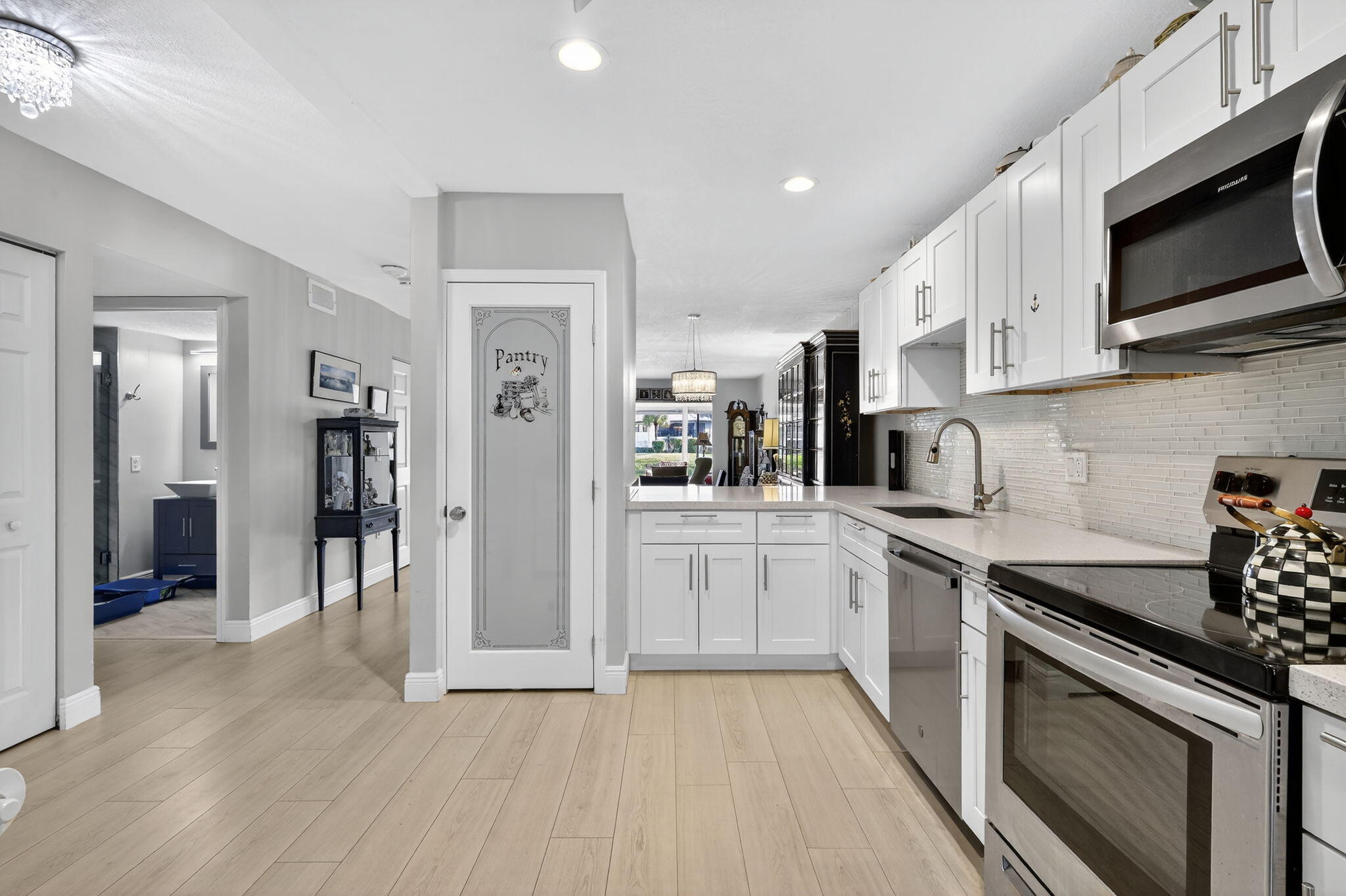 36 Southport Lane, Unit C Boynton Beach, FL 33436 - Photo 6 of 69 a kitchen with stainless steel appliances granite countertop a stove top oven a refrigerator a sink and dishwasher with wooden floor