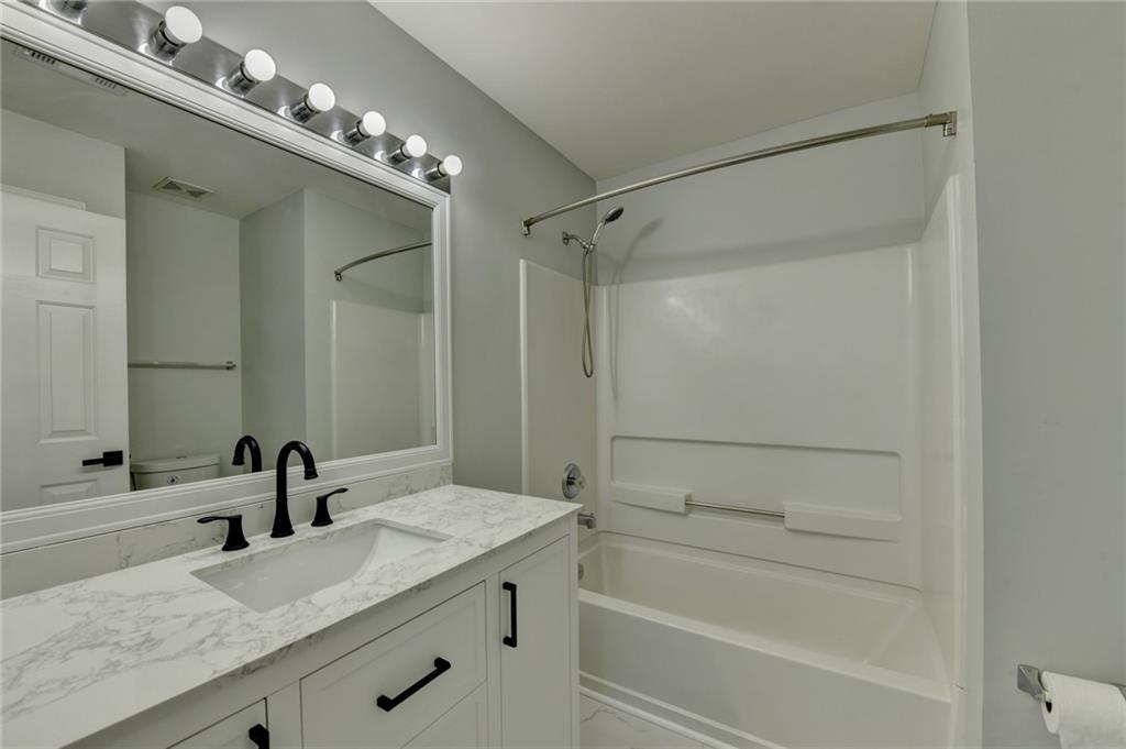3977 Howell Park Road Duluth, GA 30096 - Photo 24 of 25 a bathroom with a granite countertop sink a toilet and a mirror