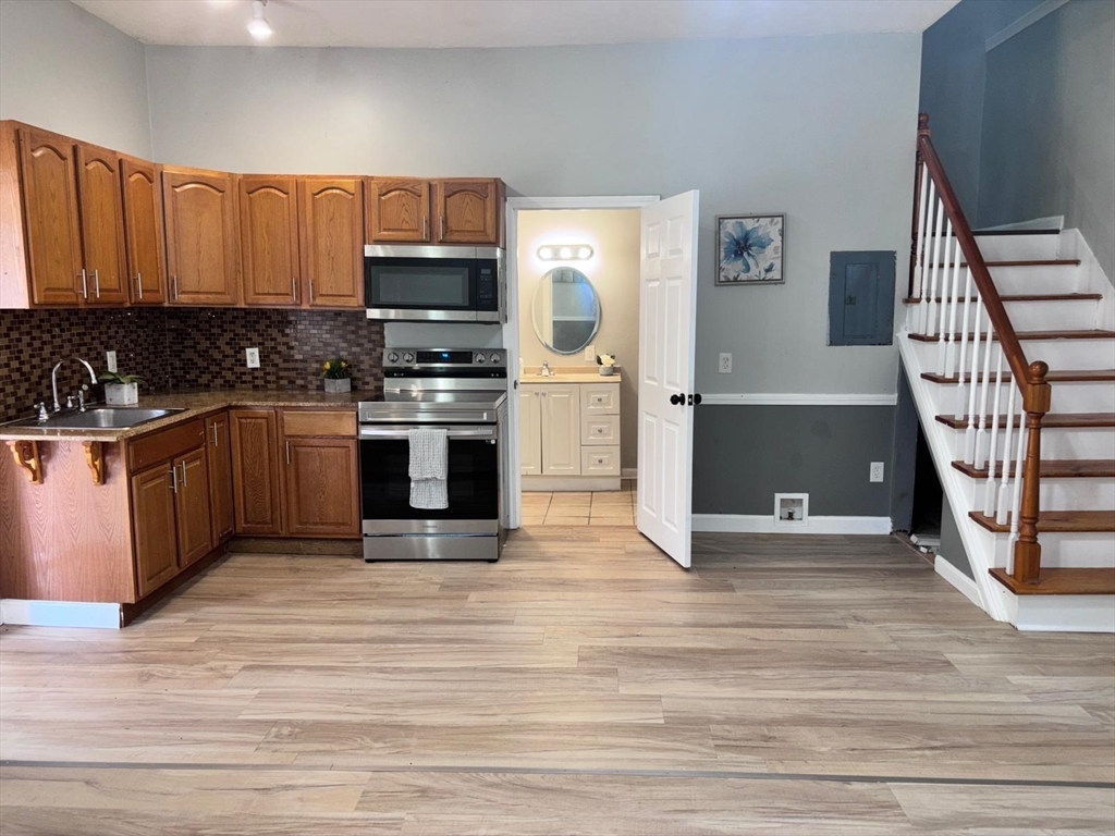 26 Main Street, Unit 2 Spencer, MA 01562 - Photo 2 of 12 a kitchen with stainless steel appliances granite countertop a stove a sink and a refrigerator