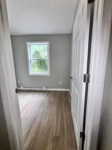 a view of a room with wooden floor and window