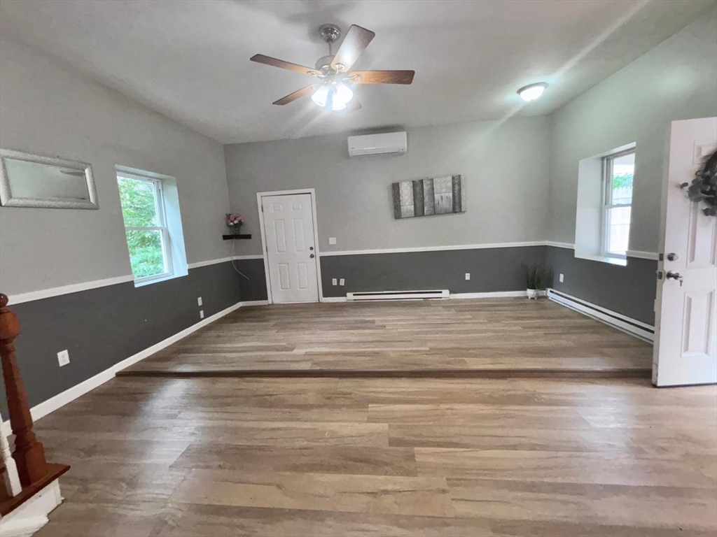 26 Main Street, Unit 2 Spencer, MA 01562 - Photo 7 of 12 a bedroom with a bed and a chandelier