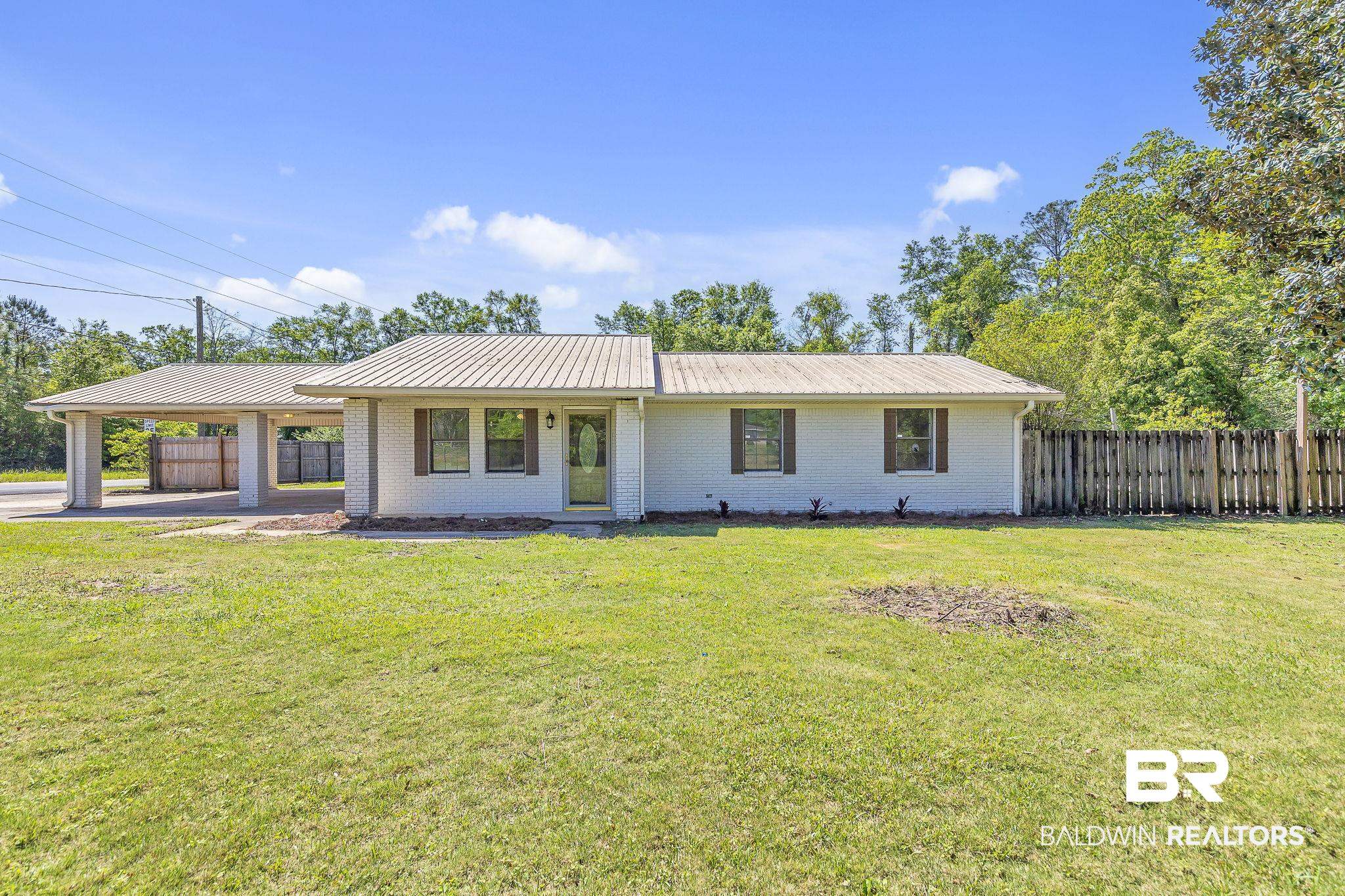 11964 Stroh Road Daphne, AL 36527 - Photo 3 of 58 Ranch-style house with a carport, brick siding, fence, and a front lawn