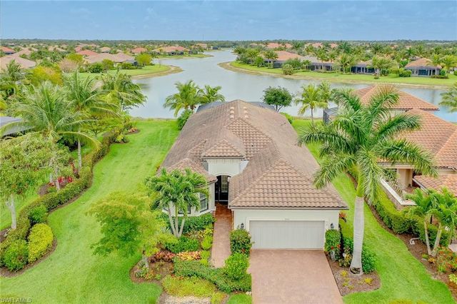 an aerial view of a house with a yard and lake view