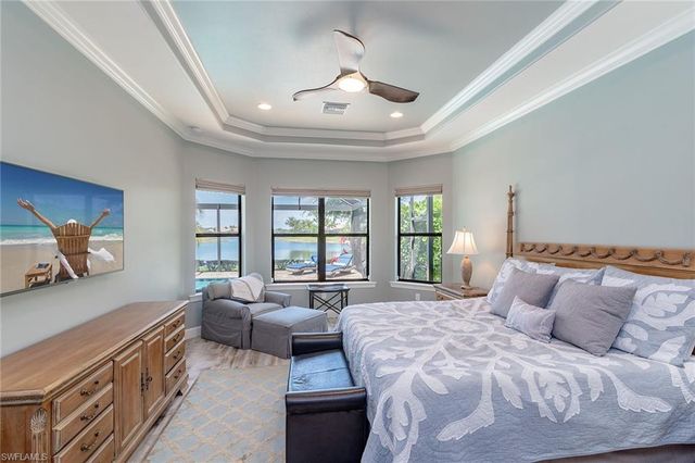 a spacious bedroom with a bed a couch and a large window with the outer view