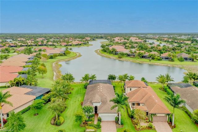 an aerial view of ocean and residential houses with outdoor space