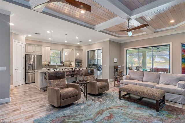 a living room with furniture kitchen view and a large window