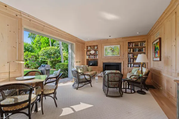 a living room with furniture a fireplace and a large window