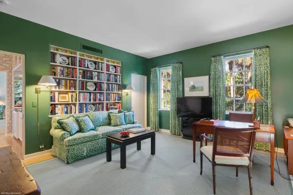 a living room with furniture and a book shelf