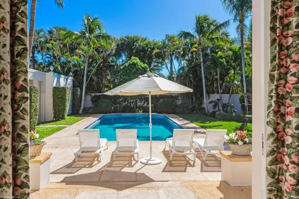 a chair and tables in the patio with a garden