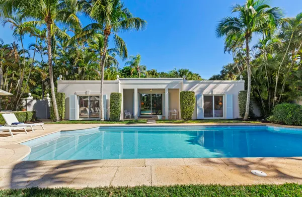 a view of a house with a swimming pool and sitting area