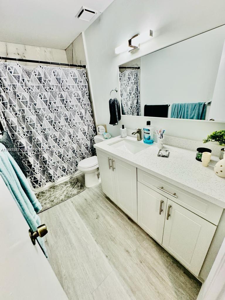 18334 Northwest 68th Avenue, Unit L Hialeah, FL 33015 - Photo 11 of 11 a bathroom with a double vanity sink mirror and shower