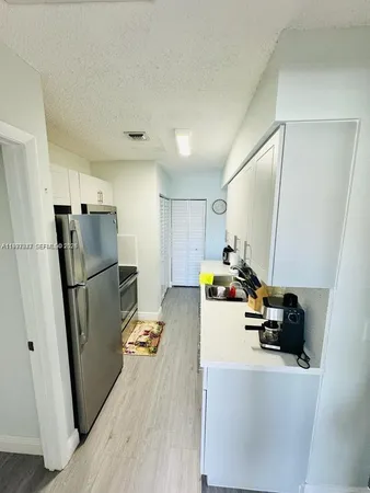 a kitchen with refrigerator and car parked