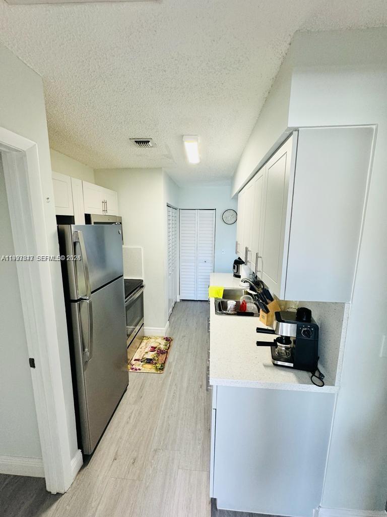 18334 Northwest 68th Avenue, Unit L Hialeah, FL 33015 - Photo 5 of 11 a kitchen with refrigerator and car parked