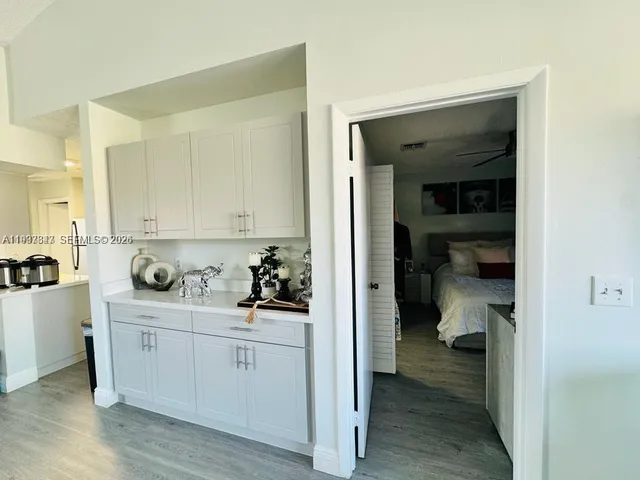 a hallway with white cabinets and wooden floor