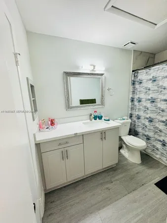 a bathroom with a sink mirror and toilet