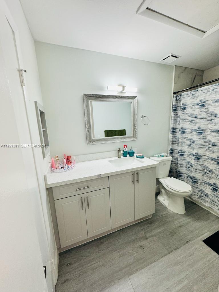 18334 Northwest 68th Avenue, Unit L Hialeah, FL 33015 - Photo 9 of 11 a bathroom with a sink mirror and toilet