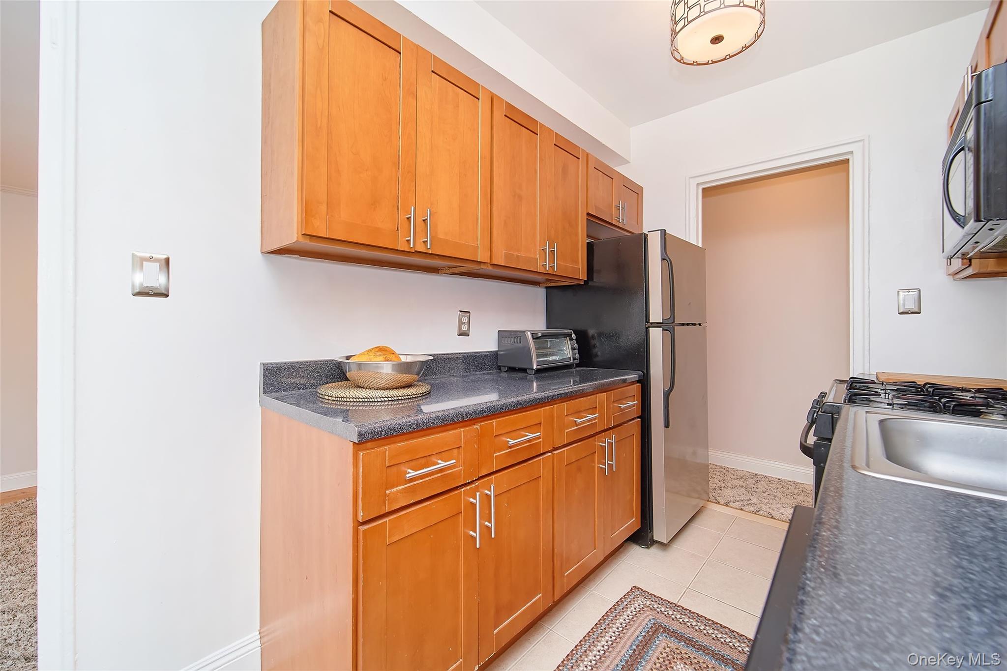 2962 Decatur Avenue, Unit 4D Bronx, NY 10458 - Photo 11 of 21 a kitchen with stainless steel appliances granite countertop a refrigerator stove and sink