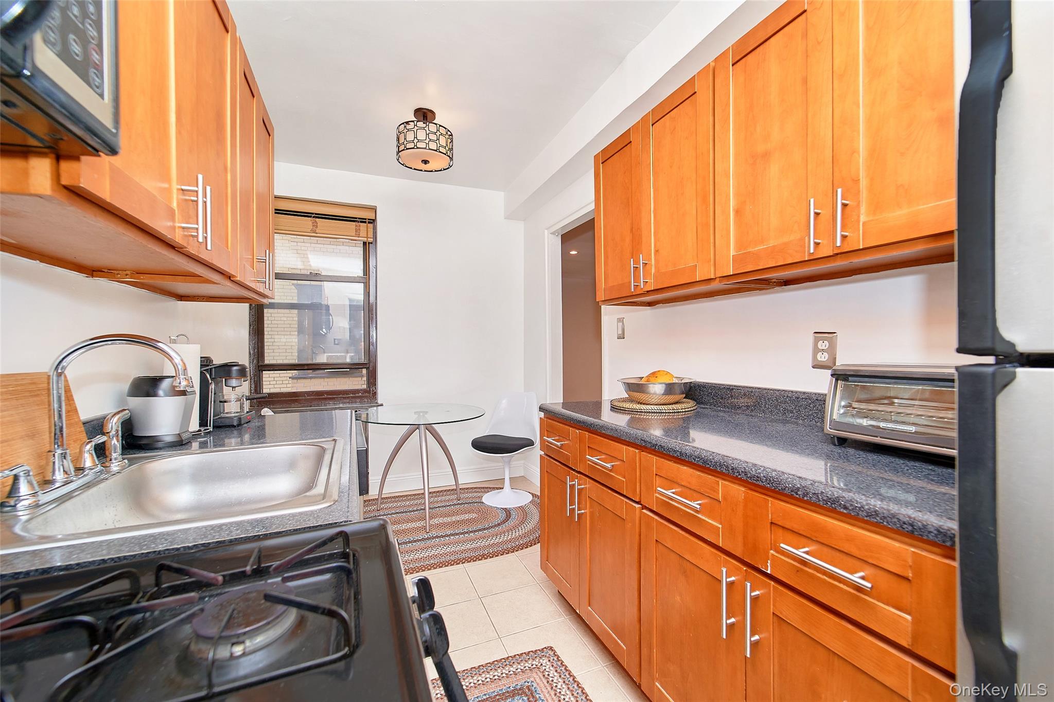 2962 Decatur Avenue, Unit 4D Bronx, NY 10458 - Photo 14 of 21 a kitchen with stainless steel appliances granite countertop a sink and a stove