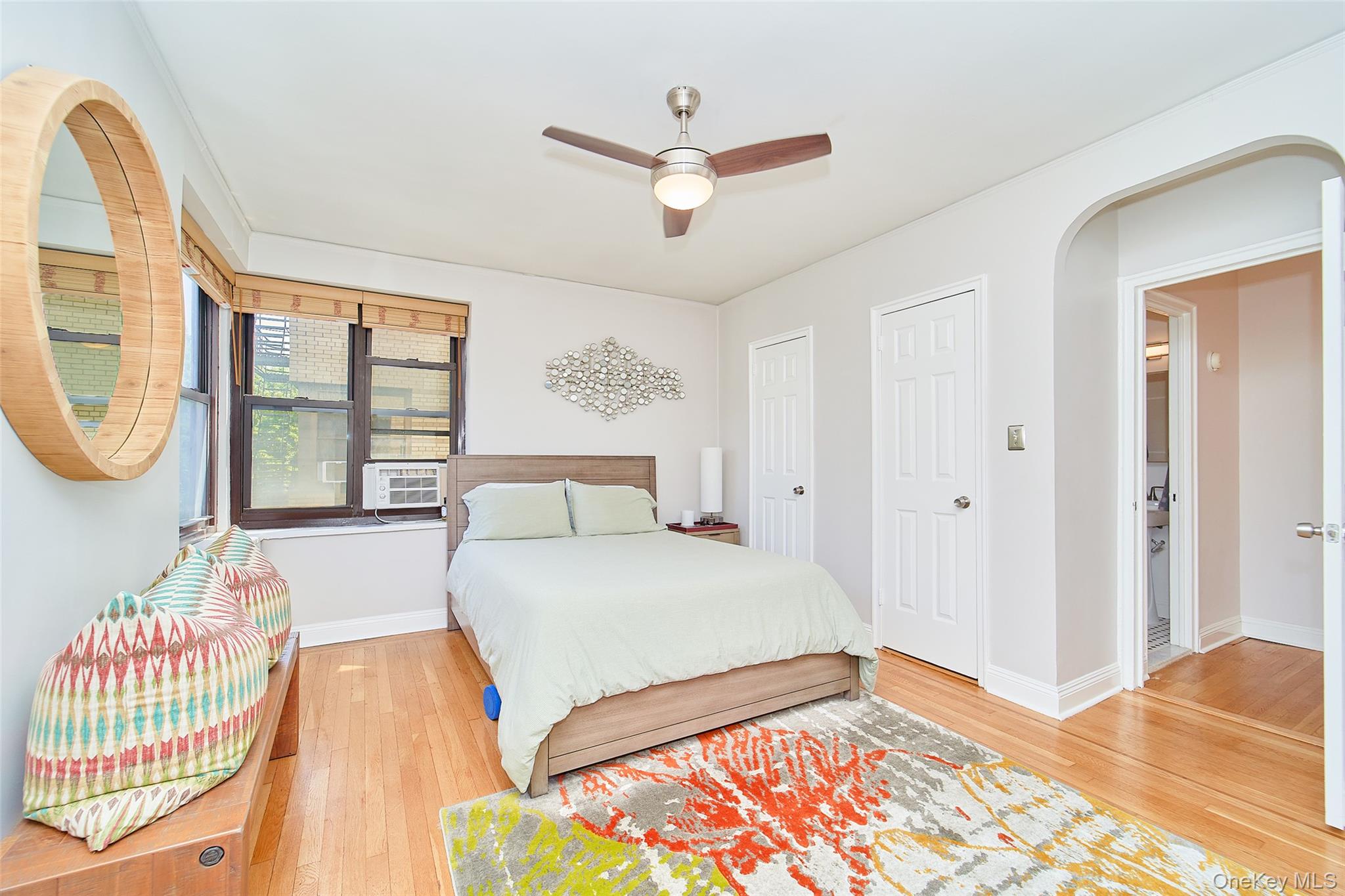 2962 Decatur Avenue, Unit 4D Bronx, NY 10458 - Photo 17 of 21 a bedroom with a bed a mirror and a large window