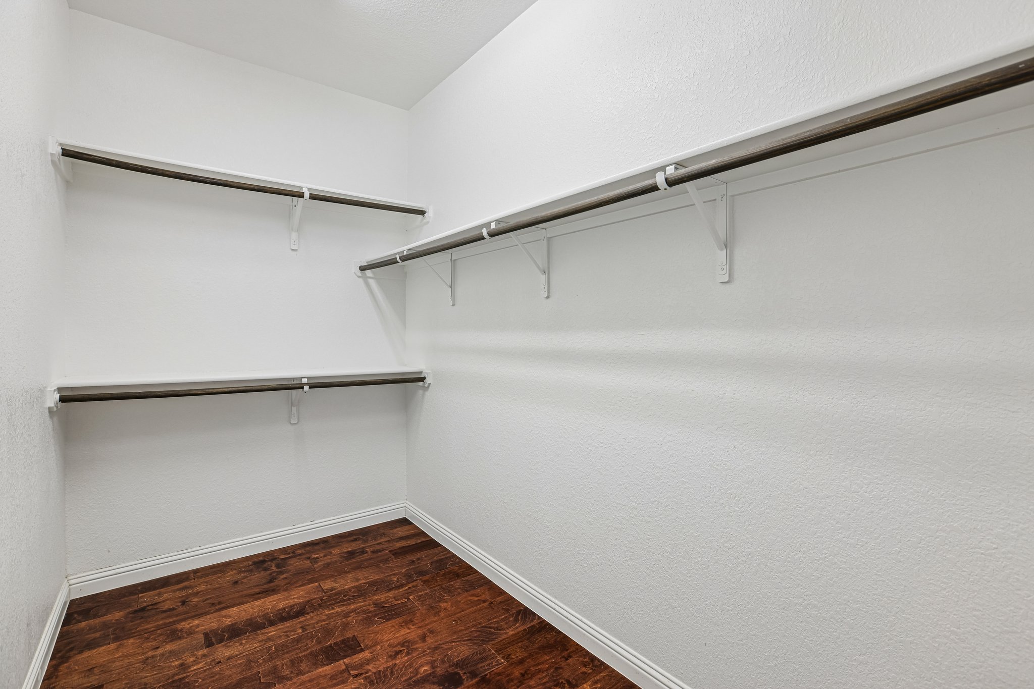 1924 Granite Springs Road Leander, TX 78641 - Photo 19 of 36 Two Large Walk in Closets located in the Primary Bedroom! Ample hanging space and rich hardwood floors define this well-appointed closet, ready for personalized organization.