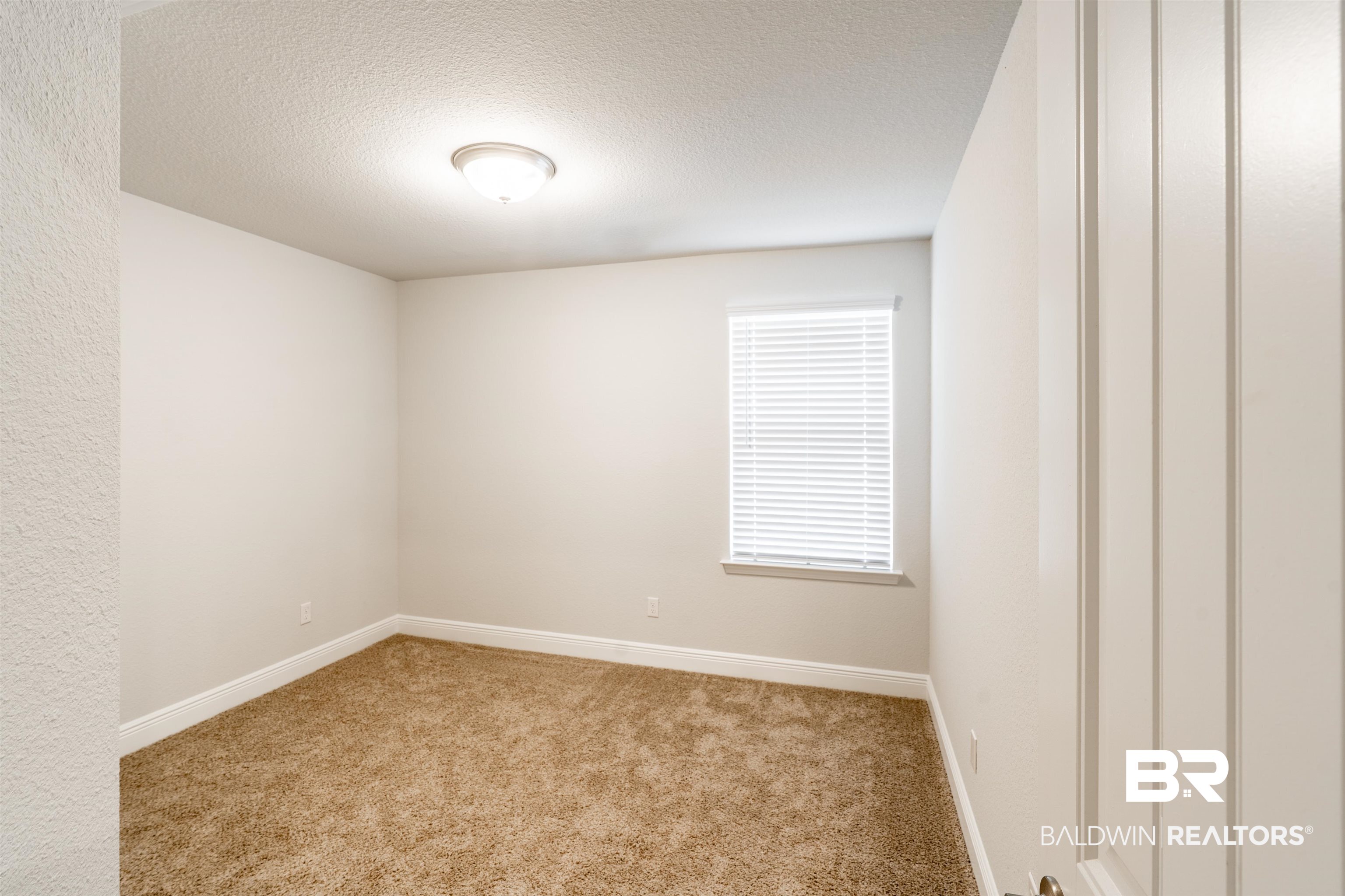 1906 Stonepine Drive South Semmes, AL 36575 - Photo 10 of 30 Carpeted spare room featuring baseboards and a textured ceiling