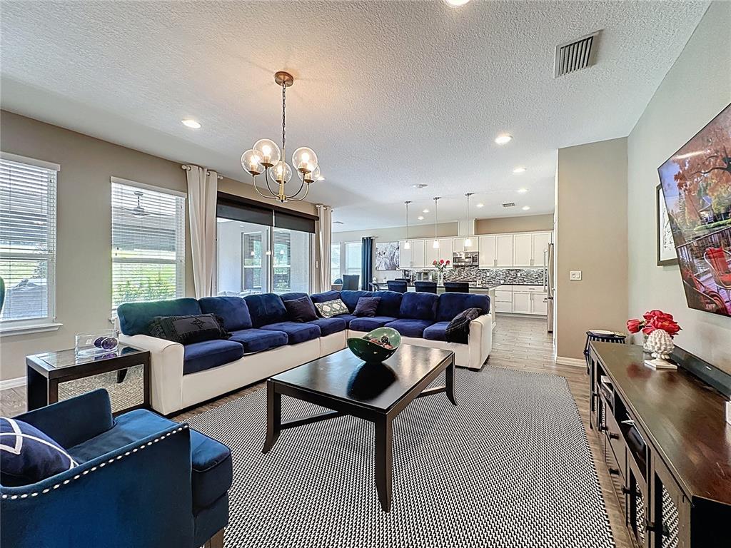 201 Silver Maple Road Groveland, FL 34736 - Photo 15 of 89 a living room with furniture and a chandelier