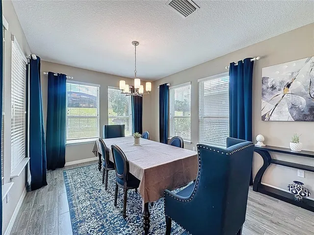 a kitchen with stainless steel appliances granite countertop a kitchen island a stove a table and chairs in it