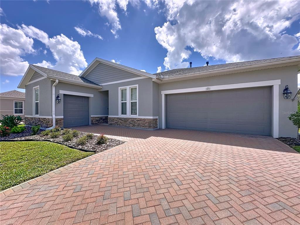201 Silver Maple Road Groveland, FL 34736 - Photo 2 of 89 a view of a house with a yard and garage