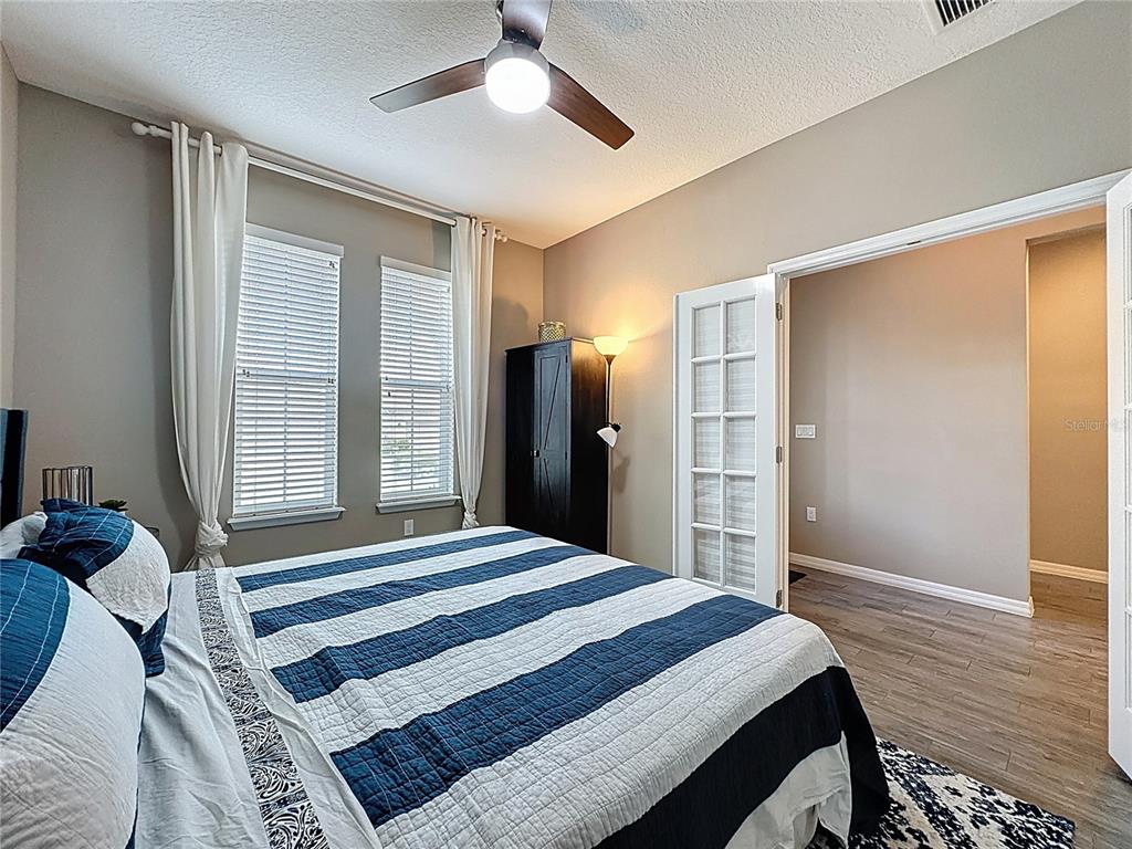 201 Silver Maple Road Groveland, FL 34736 - Photo 29 of 89 a bedroom with a bed and a chandelier