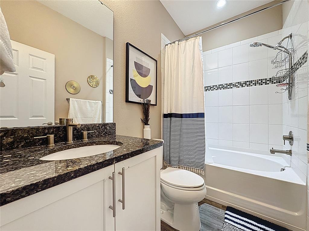 201 Silver Maple Road Groveland, FL 34736 - Photo 35 of 89 a bathroom with a granite countertop sink a toilet and a bathtub