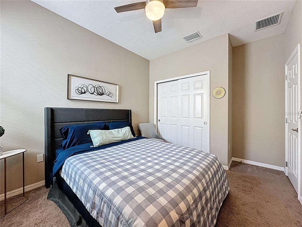 201 Silver Maple Road Groveland, FL 34736 - Photo 37 of 89 a bedroom with a bed and a chandelier