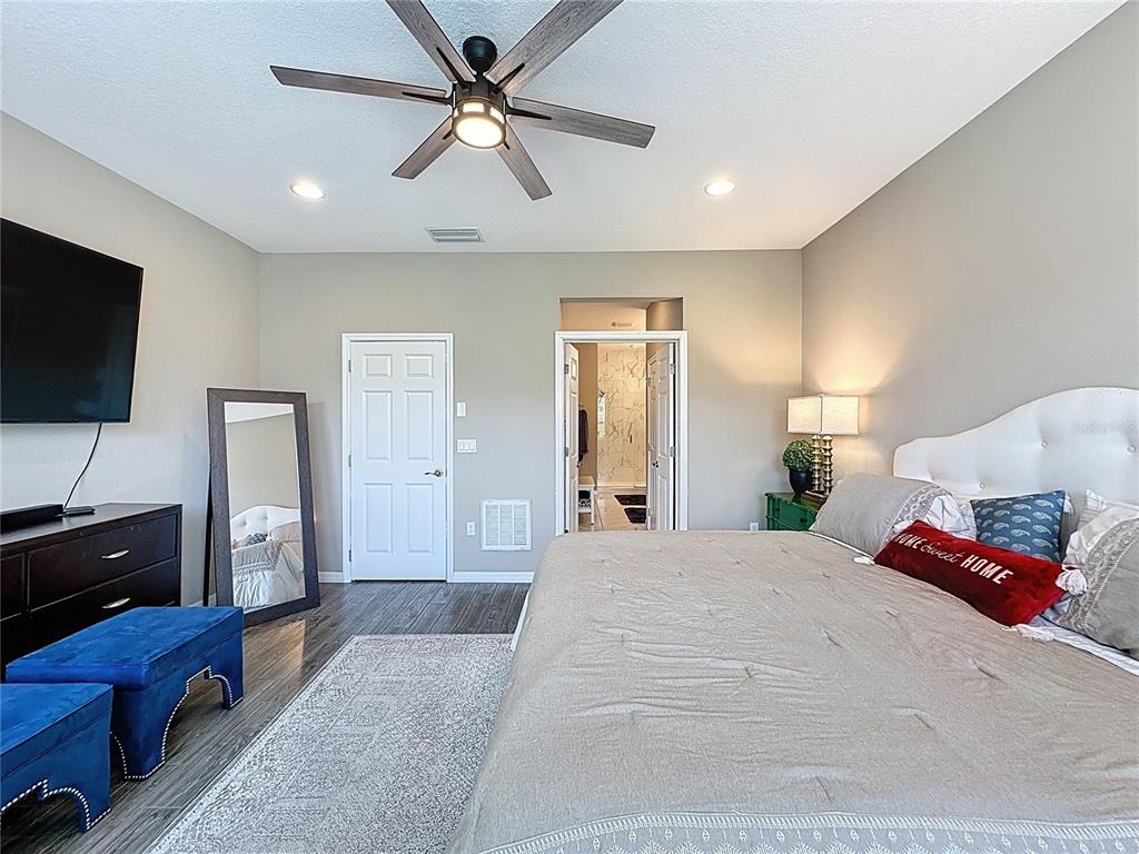 201 Silver Maple Road Groveland, FL 34736 - Photo 45 of 89 a spacious bedroom with a bed and a flat screen television