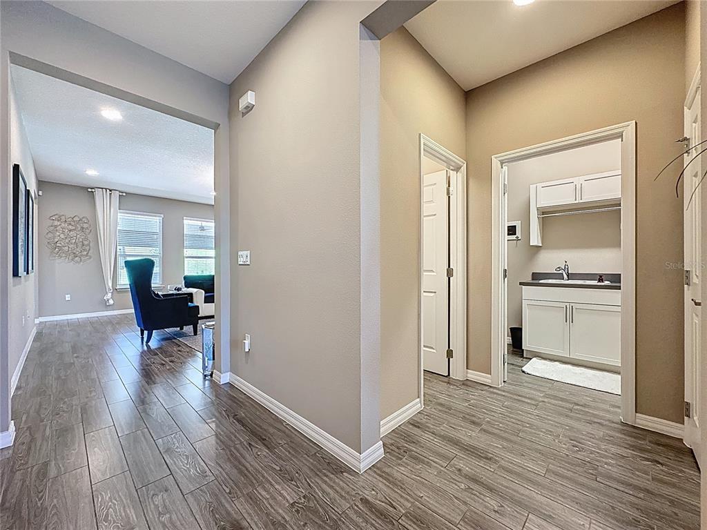 201 Silver Maple Road Groveland, FL 34736 - Photo 48 of 89 a view of a kitchen from the hallway with a wooden floor and a living room