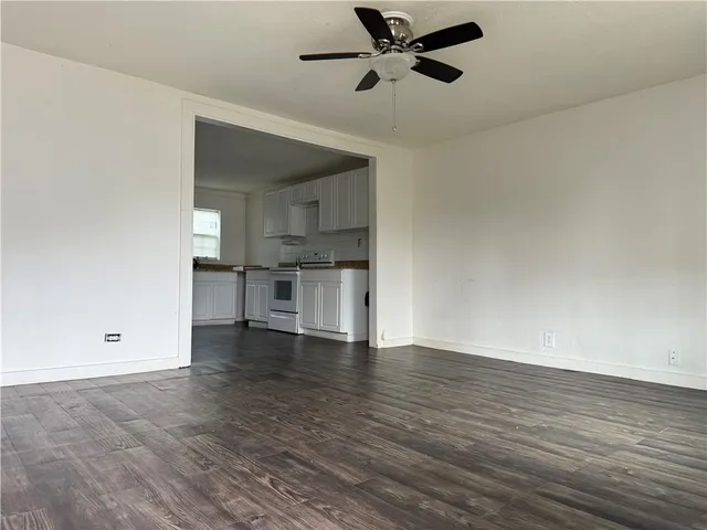 a view of empty room with wooden floor and window