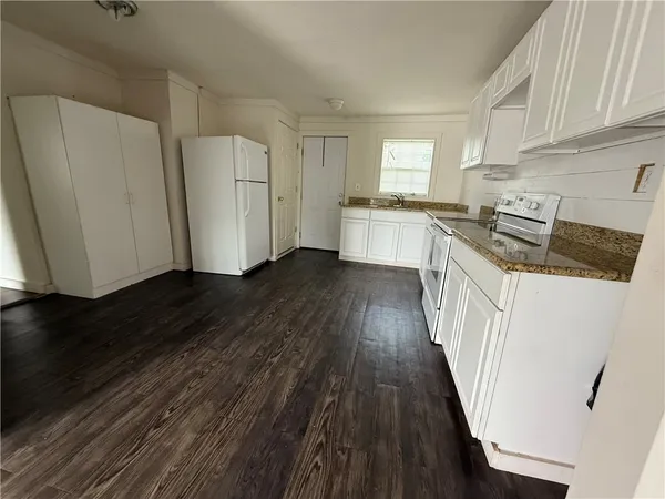 a kitchen with a sink a refrigerator a stove and cabinets