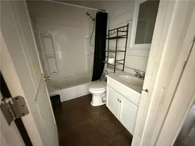 a bathroom with a sink a toilet a tub and shower