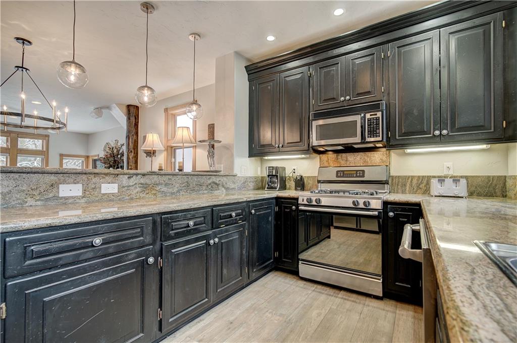 72 River Run Road Keystone, CO 80435 - Photo 15 of 35 a kitchen with kitchen island granite countertop wooden cabinets and a stove top oven