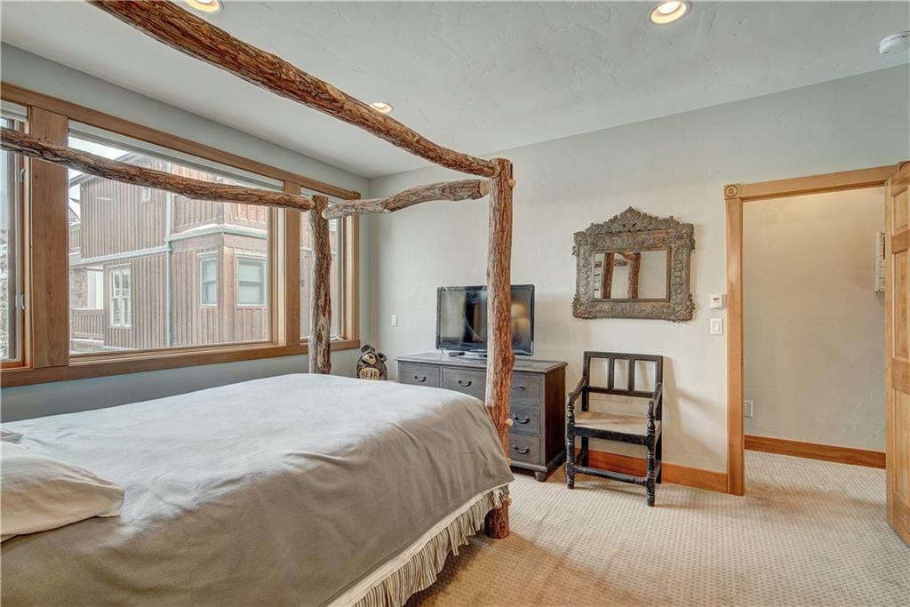 72 River Run Road Keystone, CO 80435 - Photo 24 of 35 a bedroom with a bed a table and painting on the wall
