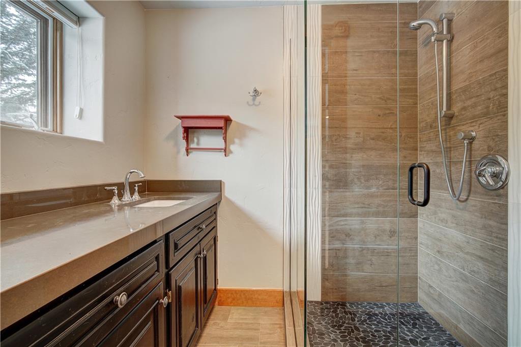 72 River Run Road Keystone, CO 80435 - Photo 33 of 35 a bathroom with a granite countertop sink a toilet and shower