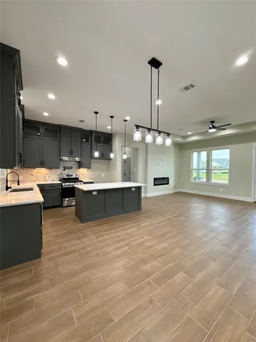 a large kitchen with kitchen island a sink stainless steel appliances and cabinets