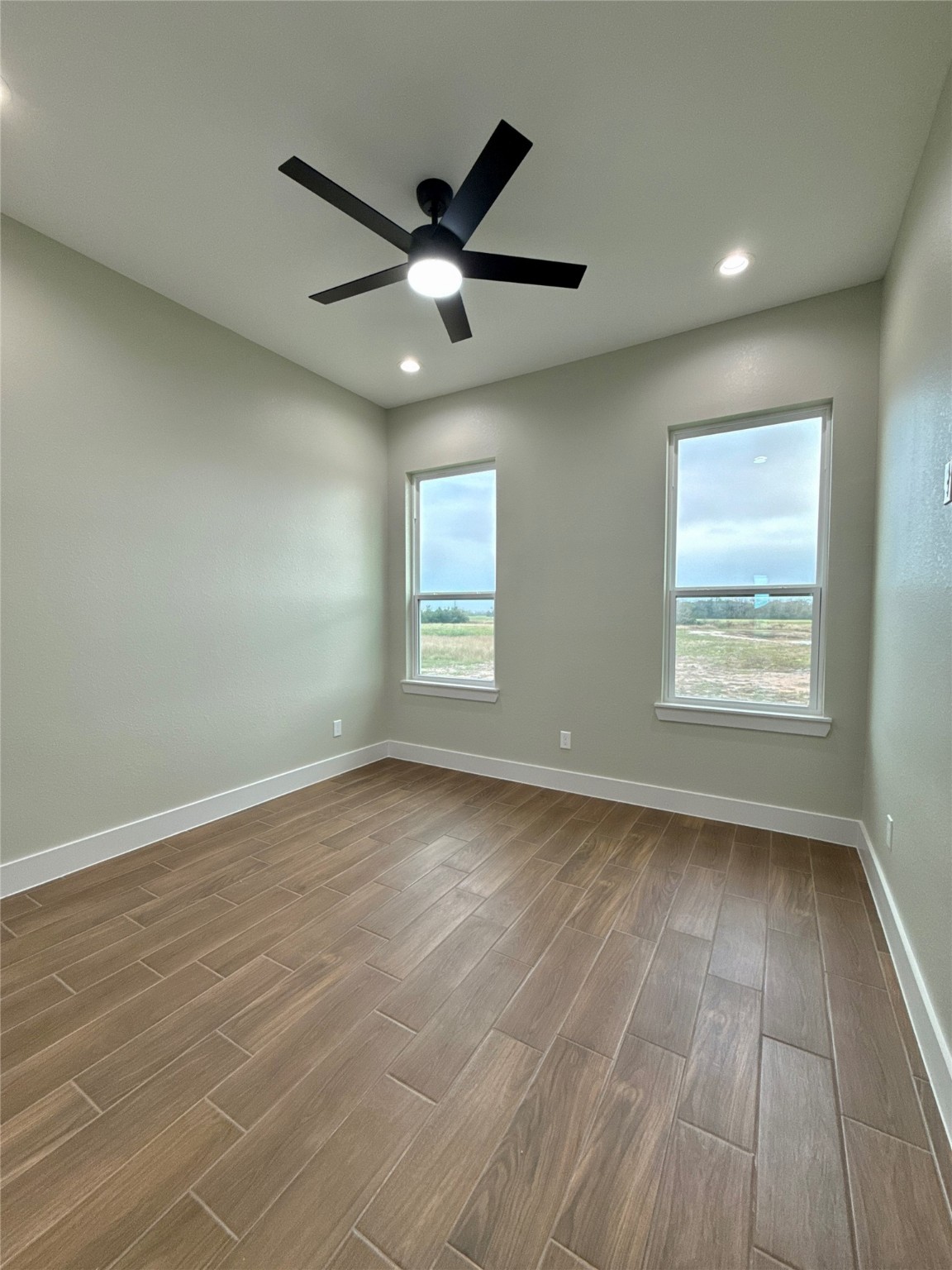 925 Buffalo Trail Angleton, TX 77515 - Photo 12 of 19 an empty room with wooden floor fan and windows