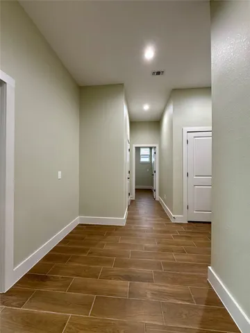 a view of a hallway with wooden floor