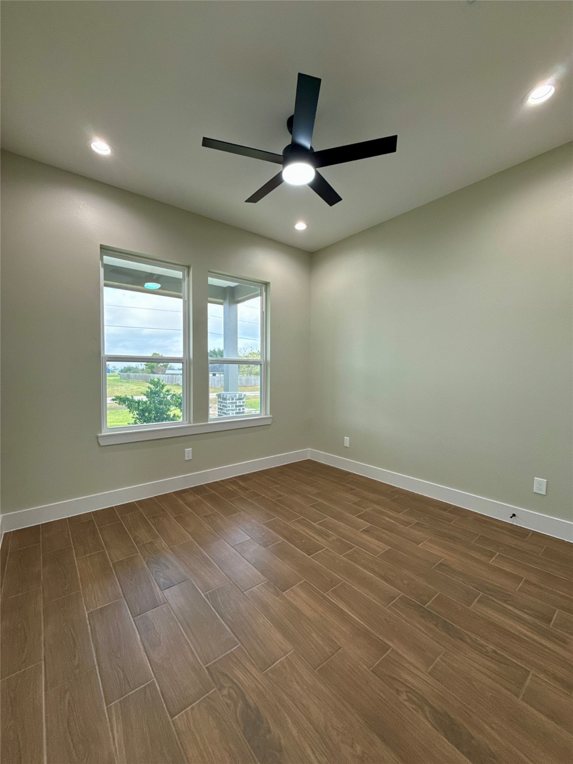 925 Buffalo Trail Angleton, TX 77515 - Photo 17 of 19 an empty room with wooden floor ceiling fan and windows